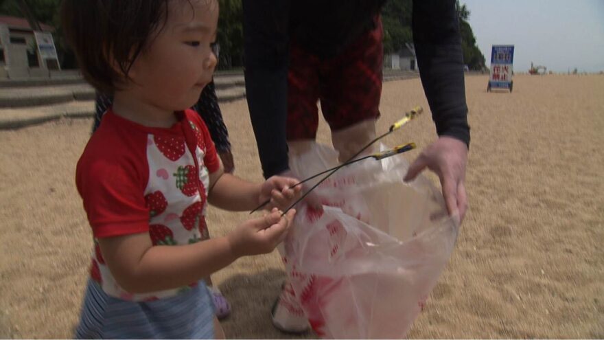 渋川海岸で海水浴客とゴミ拾い